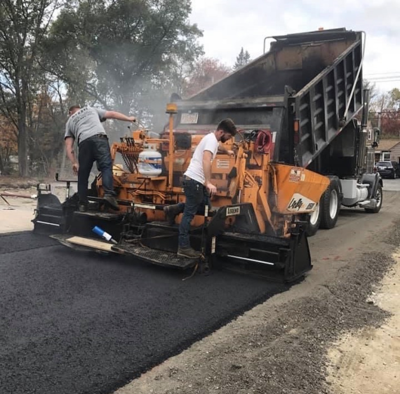 Dave Jordan's grandfather's paving crew laying asphalt behind a dump truck on a residential street