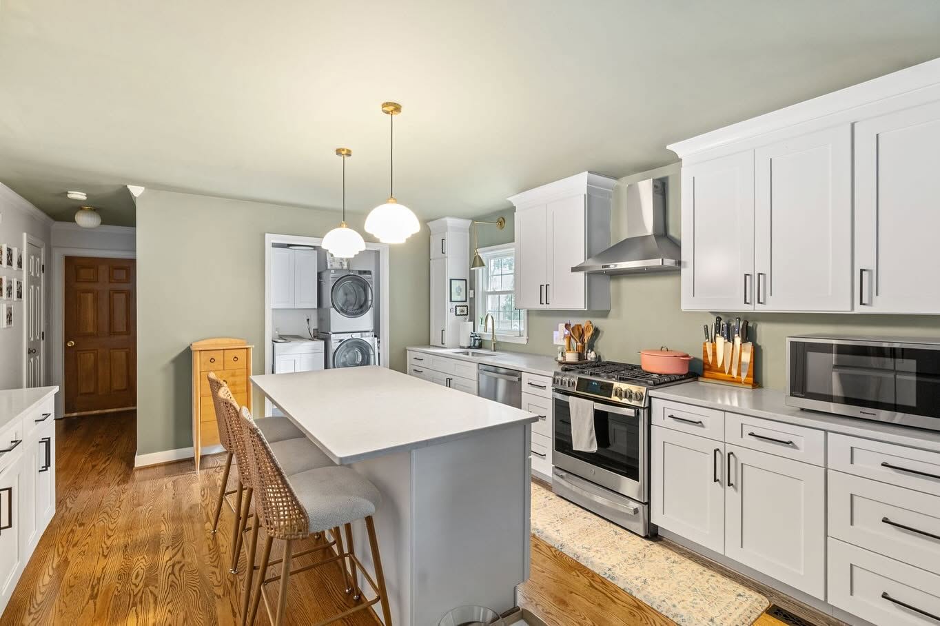 Welcoming renovated kitchen with generous cabinetry, an everyday island, and an adjacent laundry space